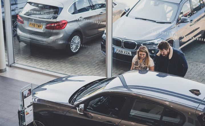 A couple looking at a car in a dealership